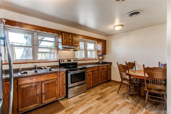 a kitchen with stainless steel appliances granite countertop a stove a sink and a microwave