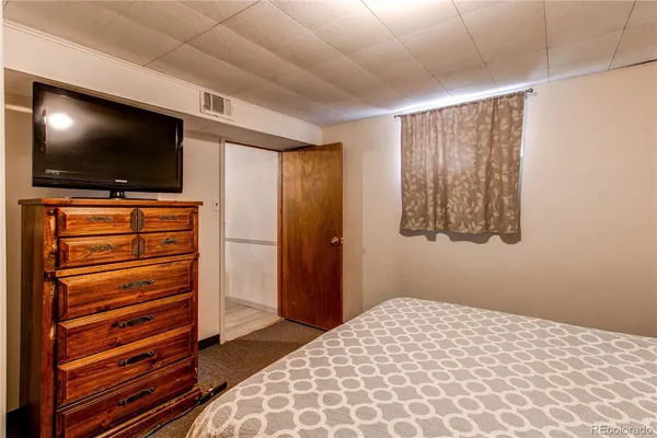 a bedroom with a bed and flat screen tv