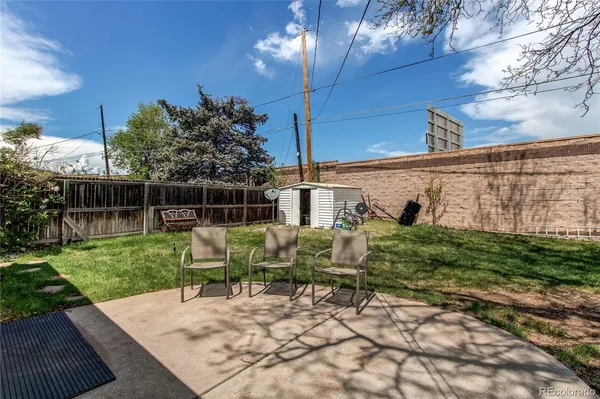 a view of a chair and table in backyard of the house