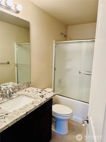 a bathroom with a granite countertop sink toilet and shower