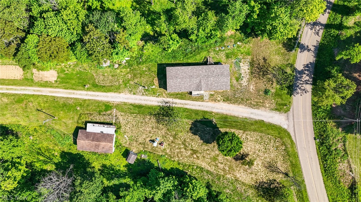 7455 Stanleyville Road Whipple, OH 45788 - Photo 36 of 37 Aerial perspective showcasing a property with a primary structure featuring a shingled roof, a secondary detached structure, and a gravel driveway