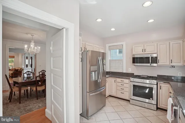 a kitchen with stainless steel appliances kitchen island granite countertop a refrigerator and a stove top oven