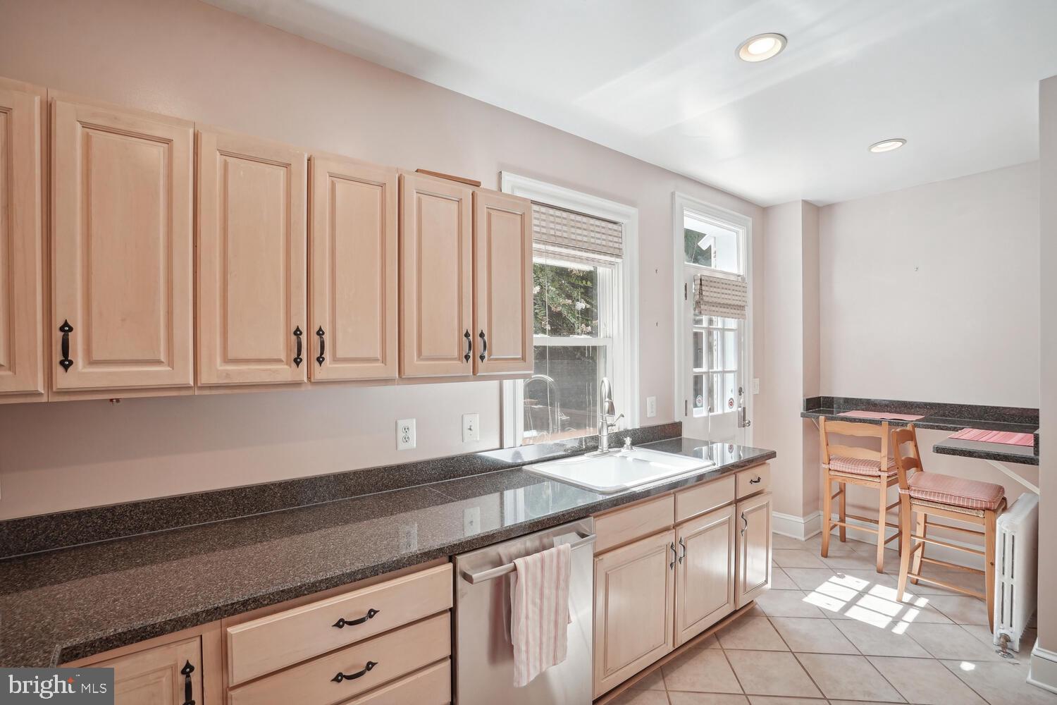 2924 Newark Street Northwest Washington, DC 20008 - Photo 10 of 26 a kitchen with granite countertop white cabinets and sink