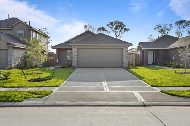 a view of a house with a big yard plants and large trees