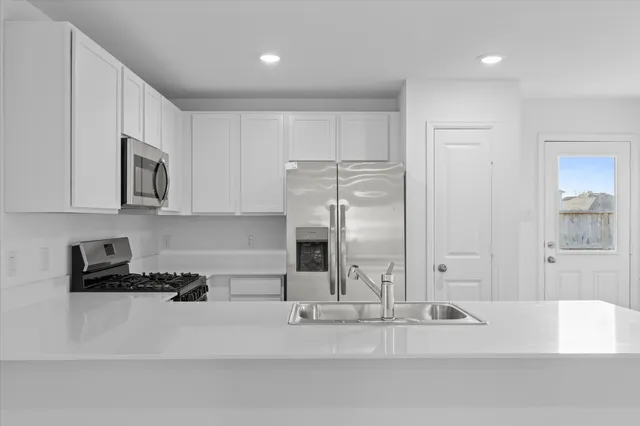 a kitchen with stainless steel appliances granite countertop a refrigerator and a sink