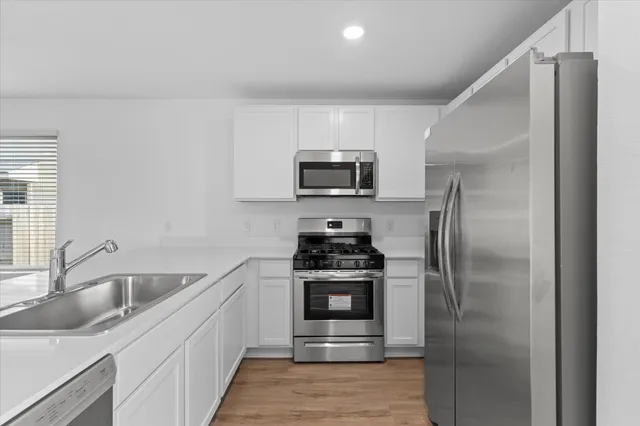 a kitchen with stainless steel appliances granite countertop a refrigerator and a sink