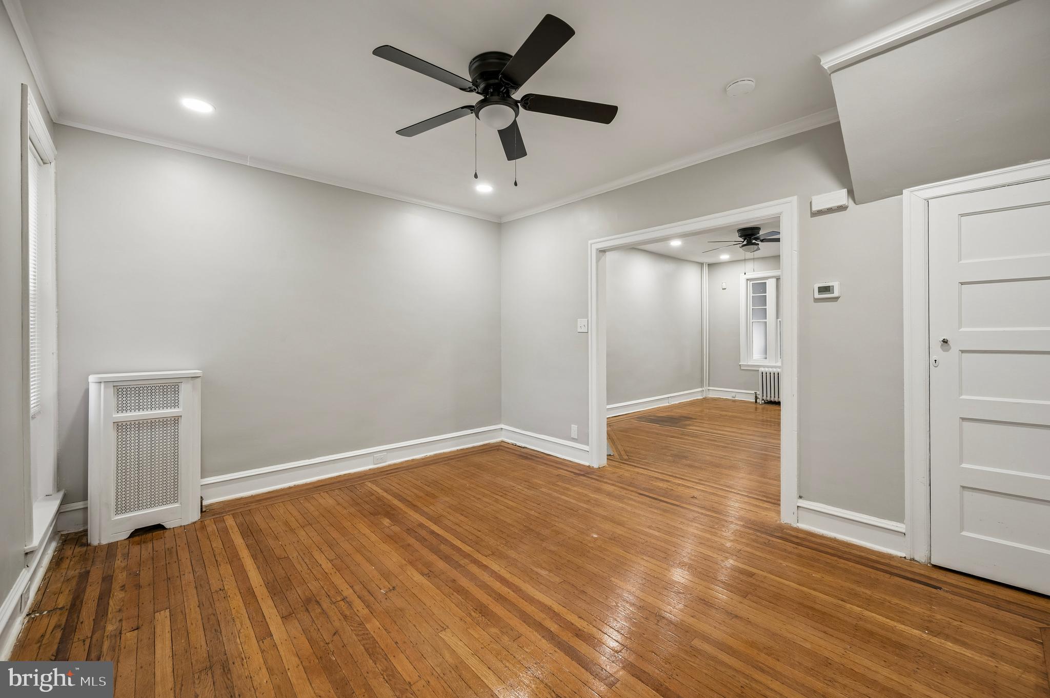 5625 Willows Avenue Philadelphia, PA 19143 - Photo 4 of 15 an empty room with wooden floor and a ceiling fan