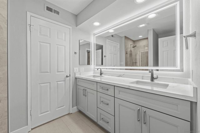 a bathroom with double sink and a mirror