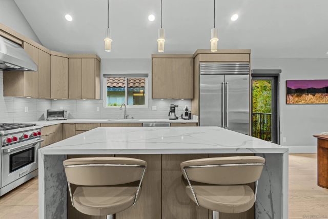 a kitchen with kitchen island a stove and a sink