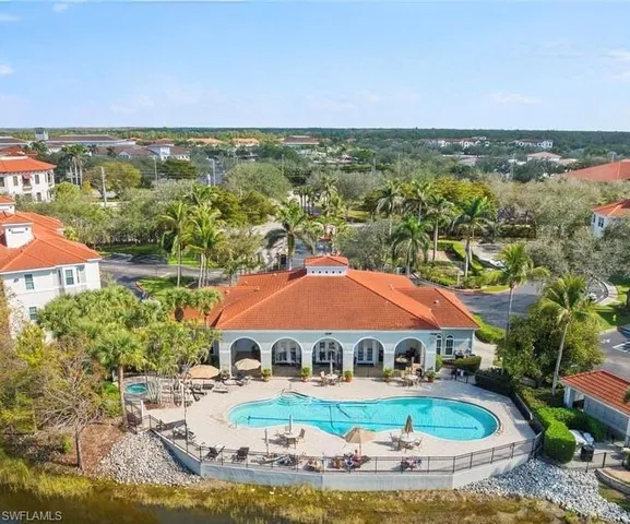 an aerial view of a house with swimming pool and lake view
