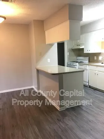 a view of a kitchen with stainless steel appliances granite countertop a stove and a sink