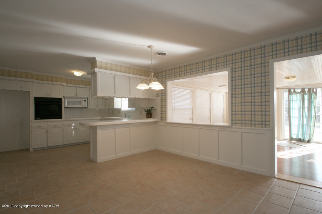3309 Lombard Road Amarillo, TX 79106 - Photo 6 of 13 a large white kitchen with white cabinets and a fireplace