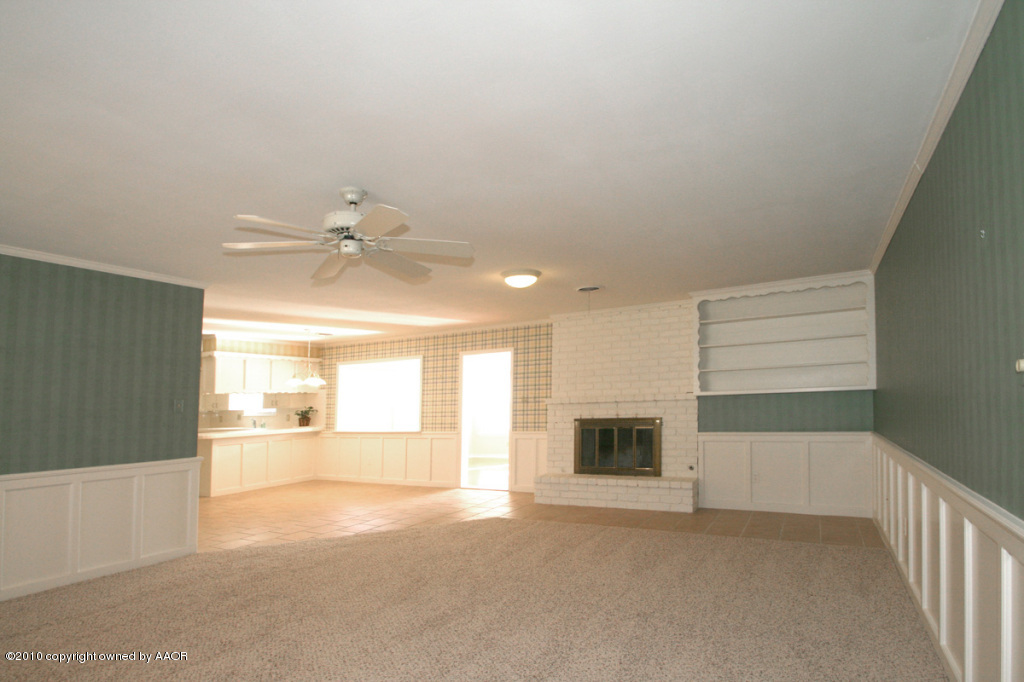 3309 Lombard Road Amarillo, TX 79106 - Photo 8 of 13 a view of a livingroom with a fireplace a ceiling fan and wooden floor