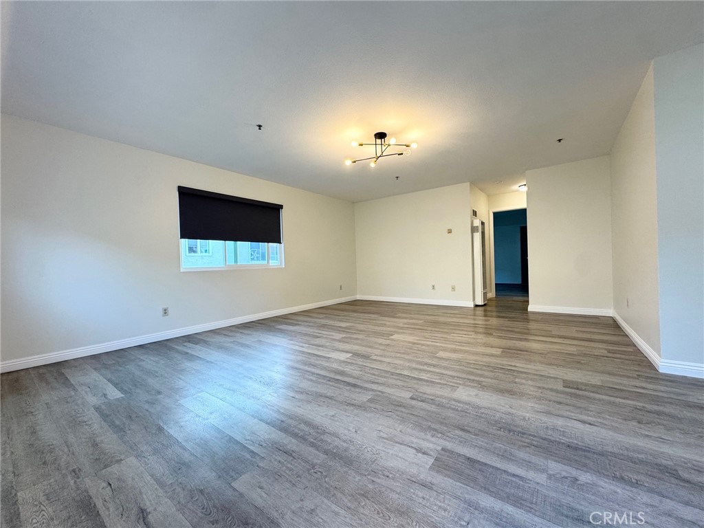 17511 Newland Street, Unit D Huntington Beach, CA 92647 - Photo 3 of 15 an empty room with wooden floor and windows