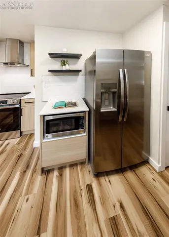 a kitchen with wooden floor and a stove top oven