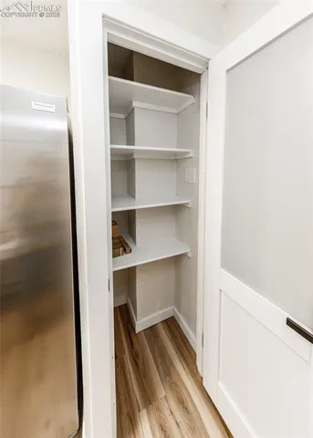 a view of a walk in closet with wooden floor