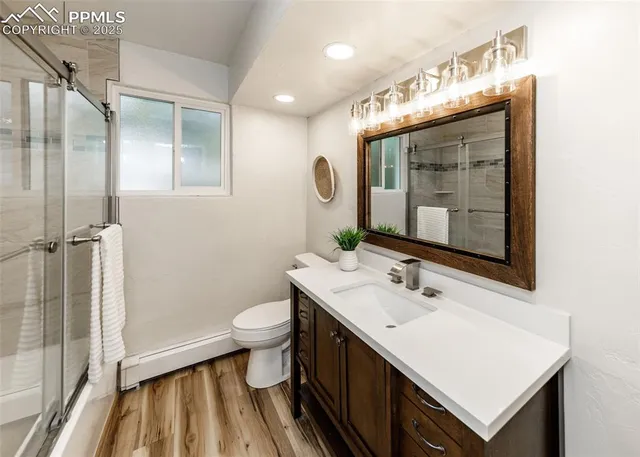 a bathroom with a sink a toilet a mirror and shower