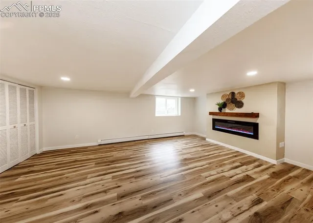 a view of empty room with wooden floor