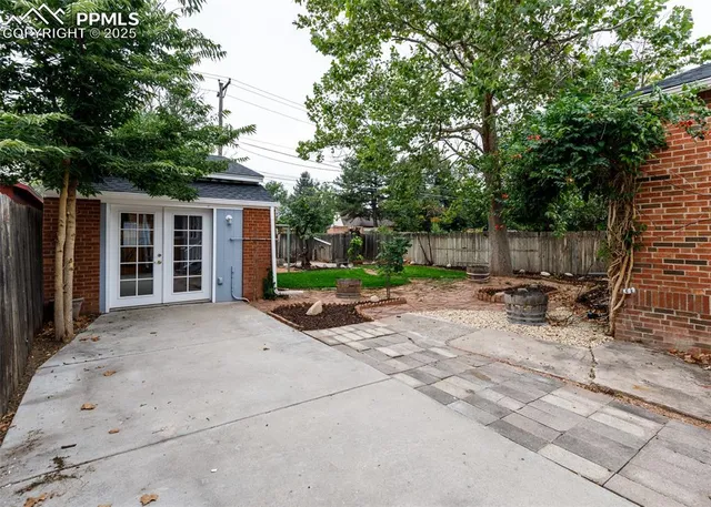 a view of backyard with a table and chairs and potted plants