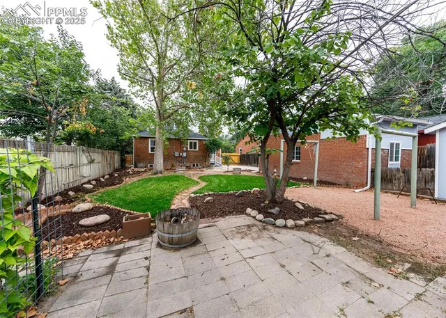 a view of a patio with table and chairs potted plants and large tree