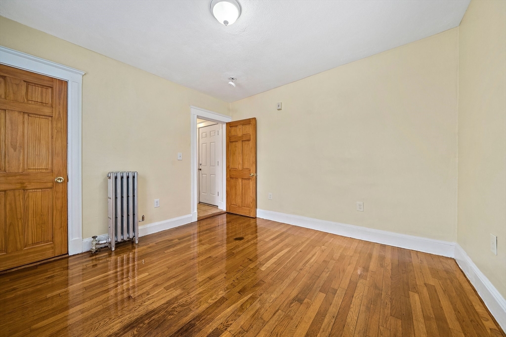 742 River Street, Unit 1 Boston, MA 02136 - Photo 10 of 17 an empty room with wooden floor and wooden door