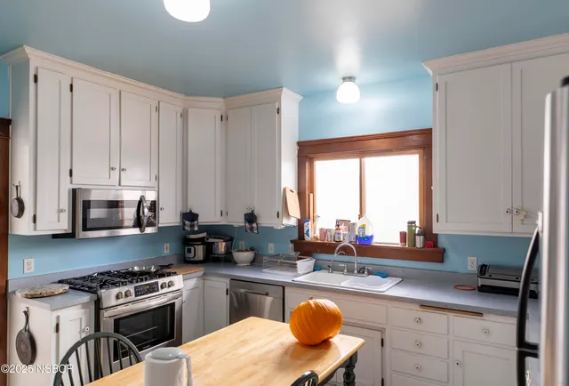 a kitchen with stainless steel appliances granite countertop a stove a sink dishwasher and cabinets with wooden floor