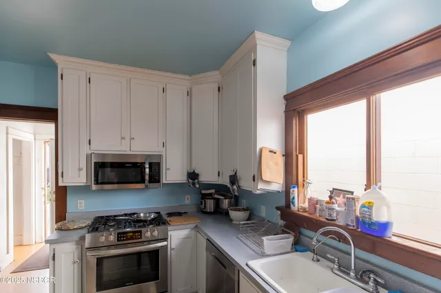 a kitchen with stainless steel appliances a stove sink and cabinets