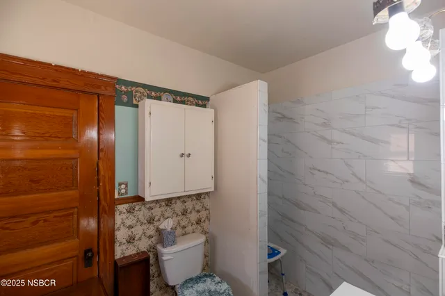 a bathroom with a toilet and a shower