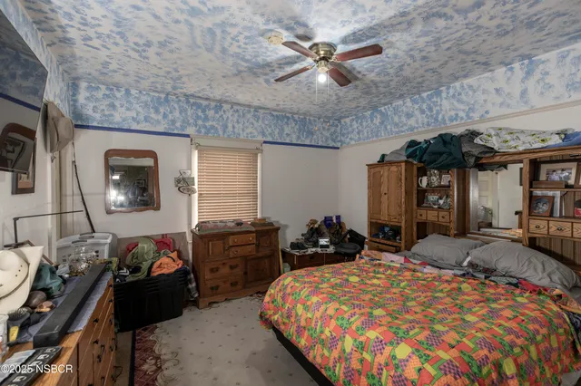 a bedroom with a bed a dresser and chair