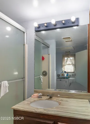 a bathroom with a sink a mirror and shower