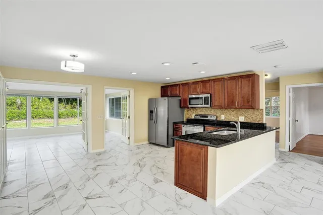 a kitchen with stainless steel appliances granite countertop a stove a sink and a refrigerator