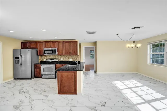a kitchen with stainless steel appliances granite countertop a refrigerator and a stove top oven
