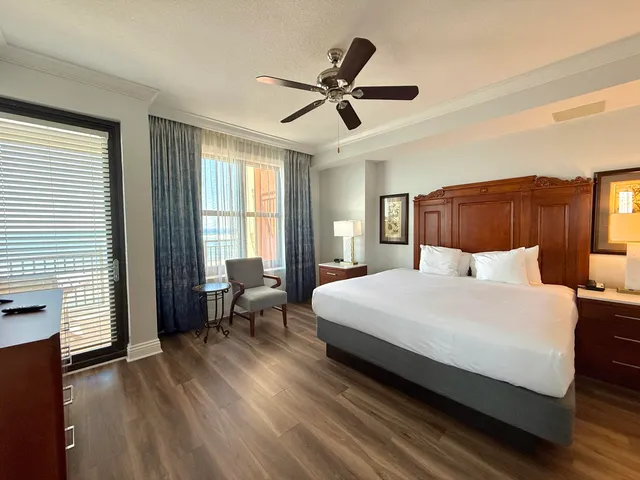 a large bedroom with a bed and wooden floor