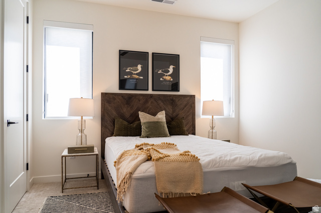 5355 Cyan Lane St. George, UT 84790 - Photo 23 of 39 Vertical windows with roller shades, wood-finish headboard, and light-toned carpeting