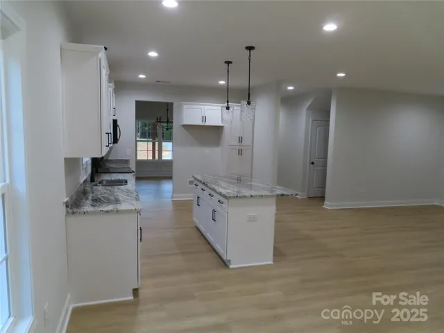 a large kitchen with stainless steel appliances kitchen island a large counter top a stove a refrigerator and a sink