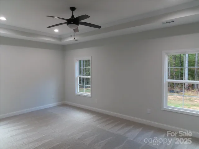an empty room with a window and a ceiling fan