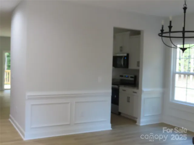 a kitchen with white cabinets and a wooden floor