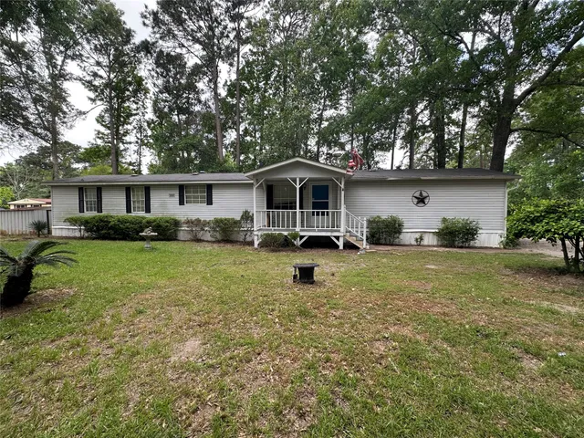 a front view of a house with a yard patio and green space