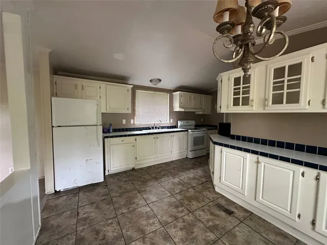 a kitchen with granite countertop a refrigerator a stove a microwave and cabinets
