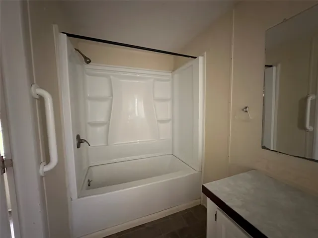a bathroom with a granite countertop sink and shower