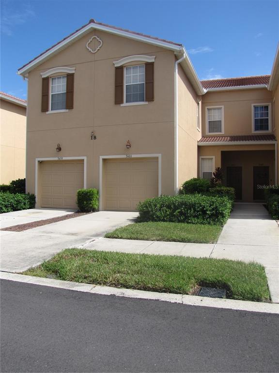 3461 Parkridge Circle, Unit 18104 Sarasota, FL 34243 - Photo 2 of 35 a front view of a house with a yard and garage