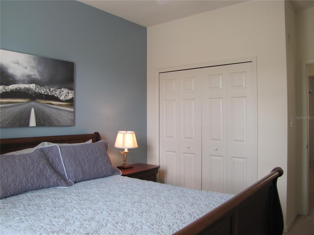 3461 Parkridge Circle, Unit 18104 Sarasota, FL 34243 - Photo 25 of 35 a bedroom with a bed and a couch