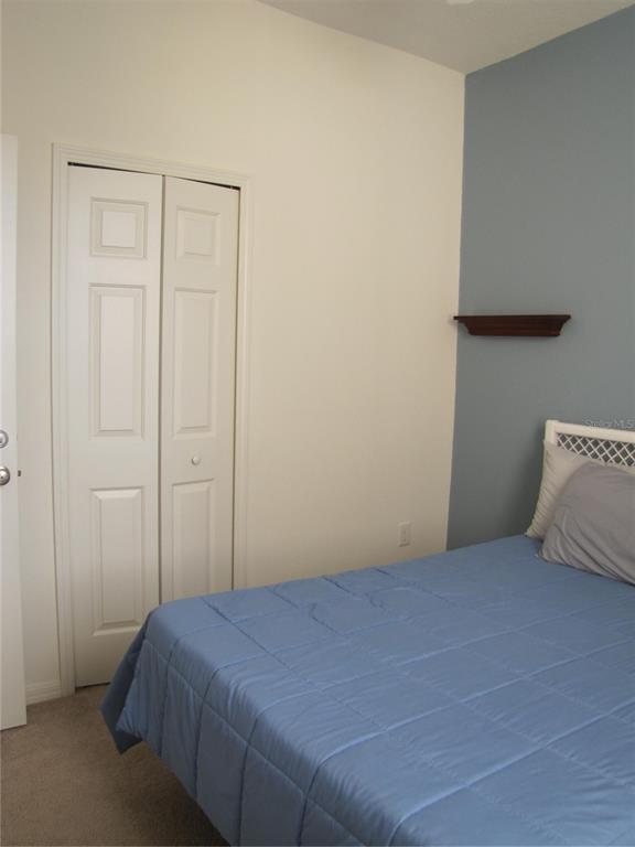 3461 Parkridge Circle, Unit 18104 Sarasota, FL 34243 - Photo 28 of 35 a bedroom with a bed and a closet