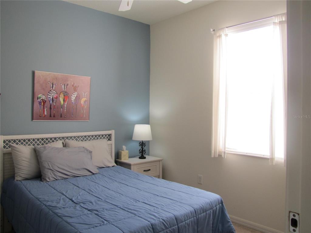 3461 Parkridge Circle, Unit 18104 Sarasota, FL 34243 - Photo 29 of 35 a bedroom with a bed and a window