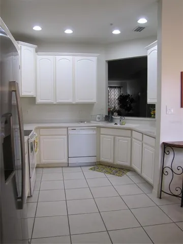 a kitchen with stainless steel appliances a sink a stove a microwave a counter top space and cabinets