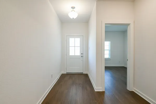 a view of a room with wooden floor and a window
