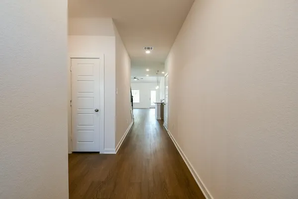 a view of a hallway with wooden floor