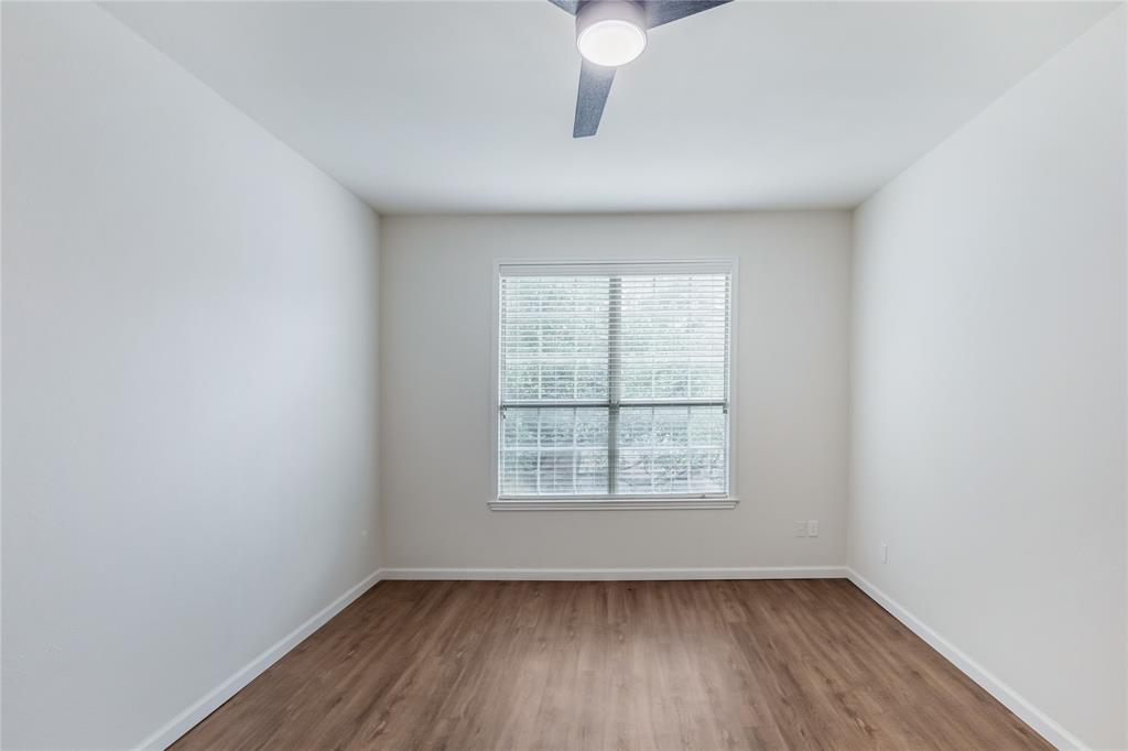12680 Hillcrest Road, Unit 4101 Dallas, TX 75230 - Photo 25 of 37 Room featuring a window with blinds, a ceiling fan with integrated lighting, wood-finish flooring, and white baseboards