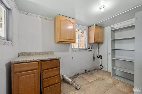 a utility room with cabinets washer and dryer