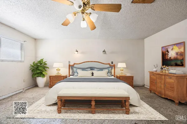a bedroom with a bed a flat screen tv and potted plant